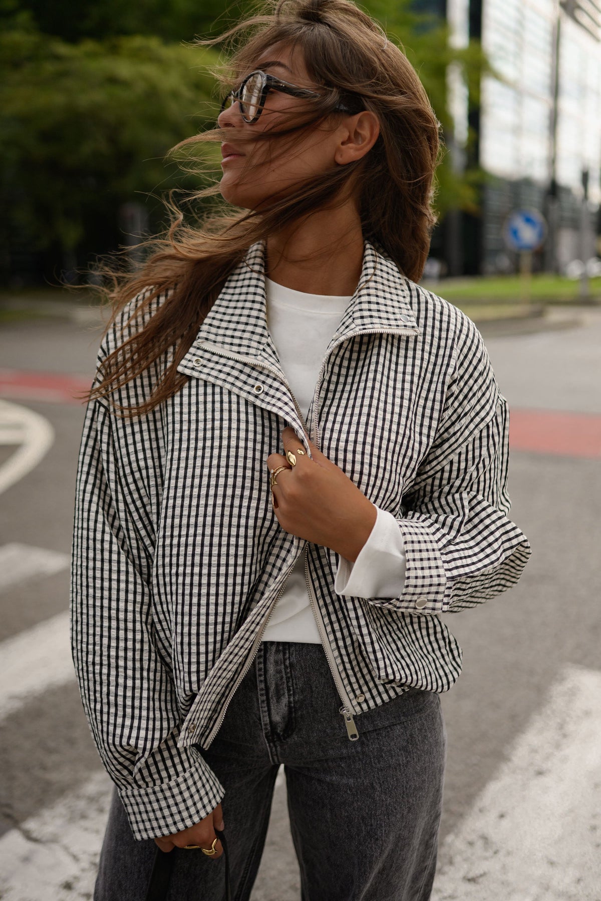 Veste courte déperlante vichy gris et blanc portée par une femme, vue rapprochée