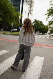 Veste courte déperlante vichy gris et blanc portée par une femme, en marchant