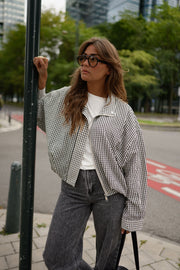 Veste courte déperlante vichy gris et blanc portée par une femme, vue de face