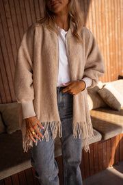 Veste ample à franges portée par une femme, vue de face, franges, jean