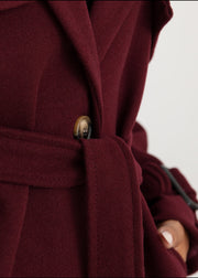 Trench oversize bordeaux à ceinture — gros plan de la ceinture en tissu nouée à la taille