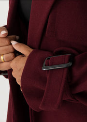 Trench oversize bordeaux à ceinture — gros plan de la manchette avec sangle et boucle