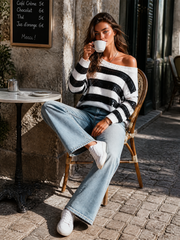 Pull rayé noir et blanc — vue portée assise à une table de café en extérieur, jean évasé