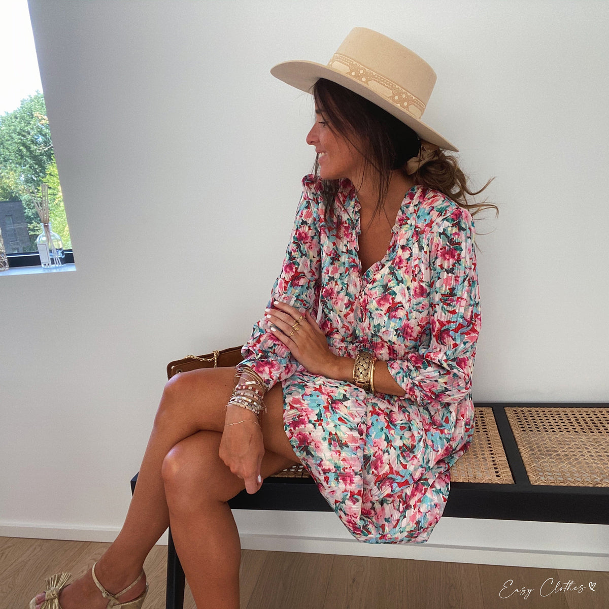 Robe fleurie à lurex portée par une femme, assise, banc, chapeau de paille