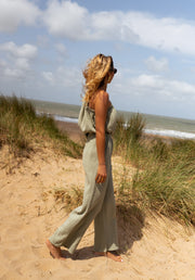 Combinaison asymétrique à poches portée par une femme, vue de profil, plage, dunes