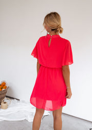 Robe courte fluide portée par une femme, vue de dos, chignon, paniers