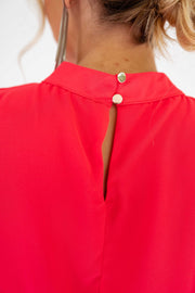 Robe courte fluide portée par une femme, vue rapprochée, col montant, bouton