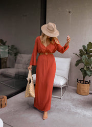 Robe longue à côtés ouverts portée par une femme, vue de face, chapeau de paille, panier