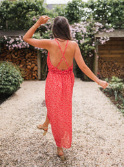 Robe fleurie à col montant portée par une femme, vue de dos, allée, bretelles croisées