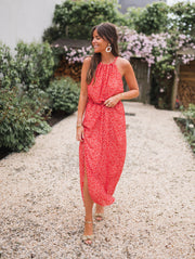 Robe fleurie à col montant portée par une femme, vue de face, allée, jardin