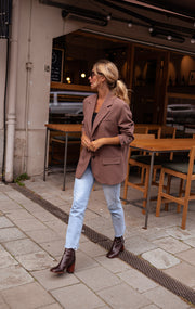 Blazer ample à épaulettes porté par une femme, silhouette entière, bottines noires, jean clair
