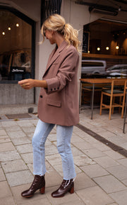Blazer ample à épaulettes porté par une femme, vue de trois-quarts, profil, jean clair
