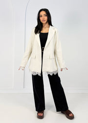 Blazer beige à détails dentelle — vue portée en pied, haut et pantalon large noirs