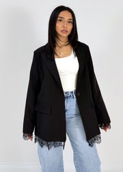 Blazer à détails dentelle — vue portée en pied, haut blanc, jean clair et sandales noires