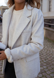 Blazer effet laine à épaulettes porté par une femme, vue rapprochée, revers, pull blanc