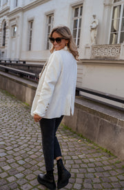 Blazer effet laine à épaulettes porté par une femme, vue de profil, rambarde, bottines, de profil