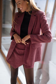 Veste à carreaux doublée portée par une femme, vue rapprochée, blazer à carreaux, mains sur la jupe