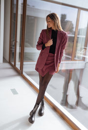 Veste à carreaux doublée portée par une femme, vue de trois-quarts, baie vitrée, bottes noires