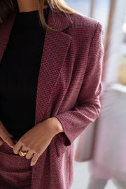 Veste à carreaux doublée portée par une femme, vue rapprochée, revers du blazer, haut noir