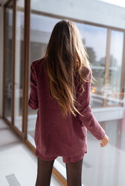 Veste à carreaux doublée portée par une femme, vue de dos, baie vitrée, cheveux longs