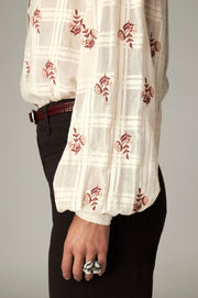 Blouse à broderies florales — détail du poignet et du côté