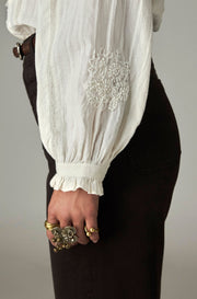 Blouse brodée à manches bouffantes — détail broderie florale et poignet