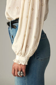 Blouse avec broderies — détail de la manche bouffante et du poignet