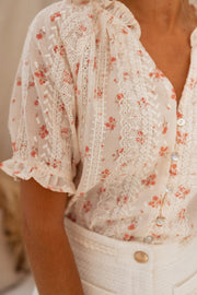 Blouse brodée à col V portée par une femme, vue rapprochée, broderies florales, manches
