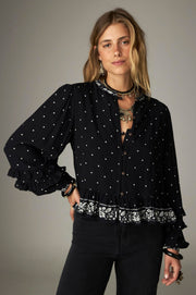 Blouse courte noire à pois — vue de face portée, coupe courte