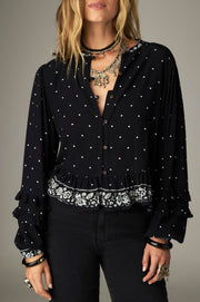 Blouse courte noire à pois — vue de face, ourlet à volants