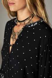 Blouse courte noire à pois — gros plan du col en V et liens
