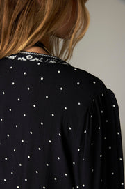 Blouse courte noire à pois — détail de l'épaule et du col de dos