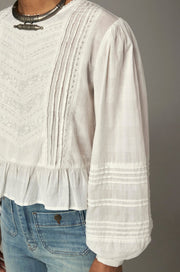 Blouse courte fluide — détail des broderies verticales sur le buste