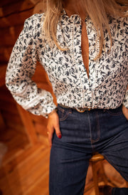 Blouse fluide à motifs portée par une femme, vue rapprochée, col ouvert, manches larges