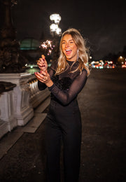 Blouse en velours à paillettes portée par une femme, vue rapprochée, rire, de nuit, pantalon noir