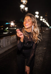 Blouse en velours à paillettes portée par une femme, vue rapprochée, sourire, de nuit