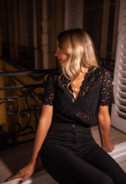 Body dentelle manches courtes porté par une femme, assise, sur le balcon, regard sur le côté
