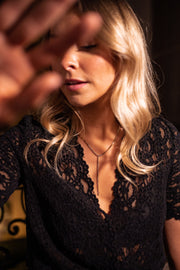 Body dentelle manches courtes porté par une femme, vue rapprochée, cheveux blonds, flou