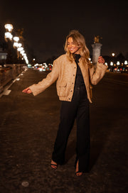Bomber entièrement pailleté porté par une femme, en marchant, de nuit, pantalon large, éclairage urbain