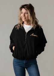 Bombers oversize en velours côtelé porté par une femme, vue rapprochée, veste noire zippée, broderie