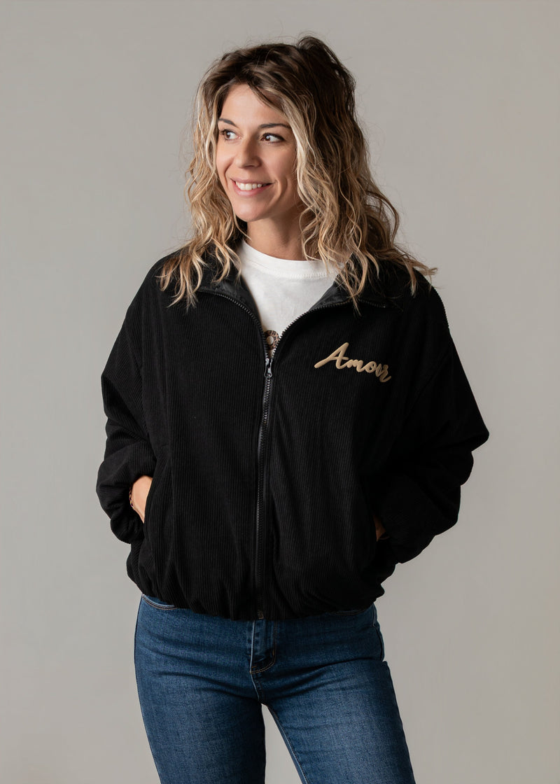 Bombers oversize en velours côtelé porté par une femme, vue rapprochée, veste noire zippée, broderie