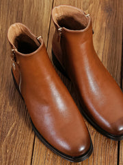 Paire de bottines camel à petit talon, vue de dessus sur parquet