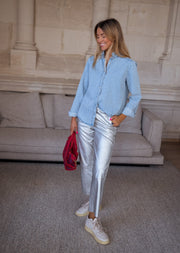 Chemise en jean à volant portée par une femme, silhouette entière, de loin, canapé