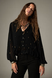 Blouse noire à pois brodés — silhouette de face avec pantalon