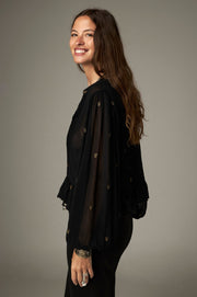 Blouse noire à pois brodés — vue de trois-quarts, manches amples