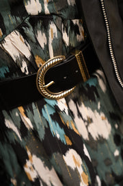 Ceinture élastique large à boucle, boucle dorée, portée sur une robe imprimée
