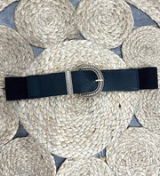 Ceinture élastique large à boucle, ceinture bleu marine, boucle argentée, sur un tapis tressé