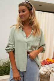Chemise en coton fluide portée par une femme, vue de face, main dans la poche, jean