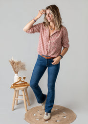 Blouse vichy à petits cœurs portée par une femme, vue de trois-quarts, main sur la tête