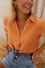 Chemise fluide à col classique portée par une femme, vue rapprochée, col, sourire